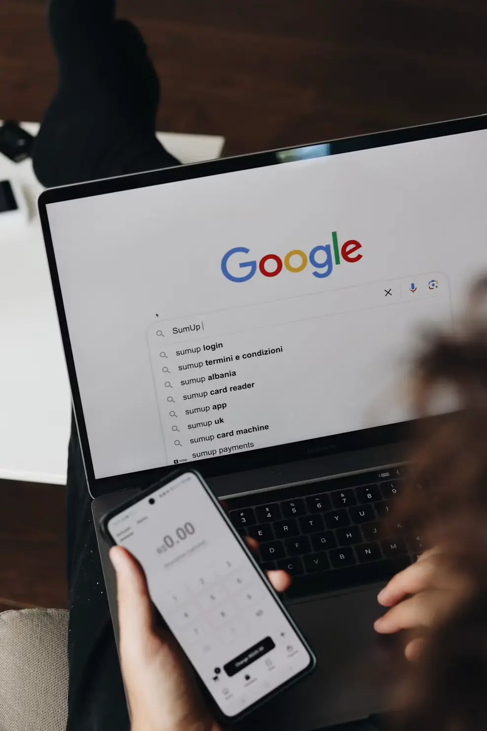 Google-søk på en datamaskin ved siden av en mobiltelefon